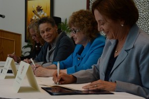 CCB MEDIA PHOTO Ramona Peters, left, Mashpee Wampanoag Tribal Historic Preservation Officer, along with Stephanie Pollack, Secretary of the Massachusetts Transportation Department, and Pam Stephenson, Division Administrator of the federal Highway Administration, sign a historic agreement.