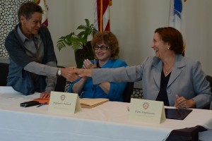 After the signing, Ramona Peters of the Mashpee Wampanoag Tribe shakes hands with Pam Stephenson of the Federal Highway Administration.